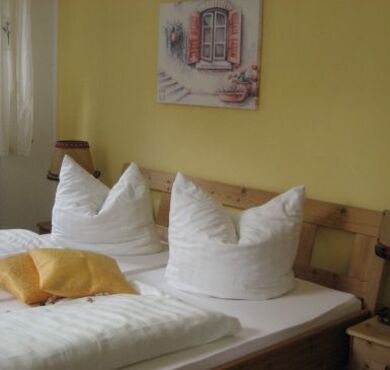 Doppelbett vor gelber Wand.