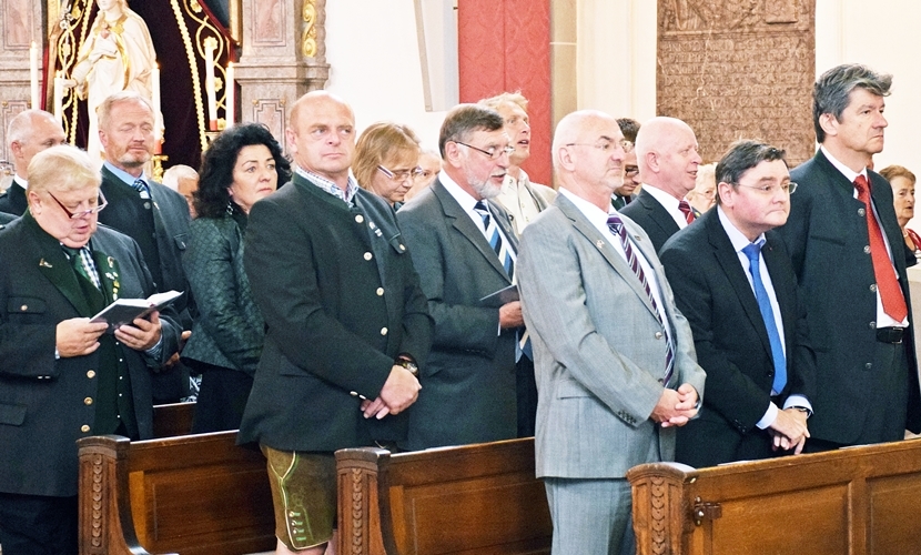 Ehrengäste stehen in der Kirche während des Gottesdienstes.