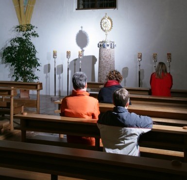 Pilger beten in der Anbetungskapelle in Altötting vor der Monstranz.