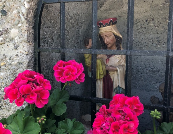 Bier sehen Sie eine Madonna am Wegmarterl in Winhöring hinter pinken Blumen
