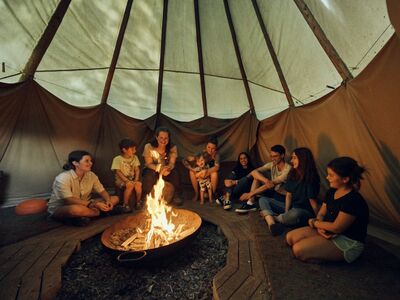 Kindergruppe vor Lagerfeuer im Zelt im Wald, Inn Natur