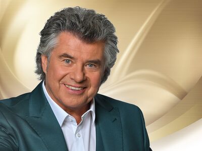 Andy Borg, Lieblingshits, Peter Alexander, Forum Altötting, Bild Kerstin Joensson Ein Mann mit grau melierten Haaren und Anzug steht vor einem hellen Hintergrund.