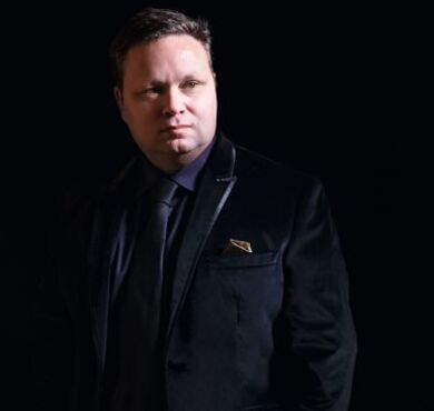 Der weltberühmte Tenor Paul Potts vor schwarzem Hintergrund.