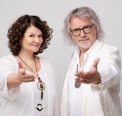 Petzenhauser & Wählt, KULTUR+KONGRESS FORUM ALTÖTTING, Foto: Hannes Höchsmann Das Kabarett-Duo Petzenhauser & Wählt in weißen Outfits bei Yoga-Posen mit esoterischem Schmuck und humorvoll übertriebenen Handbewegungen.