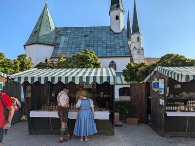Zwei Menschen stehen vor einem Stand am Altöttinger Klostermarkt.