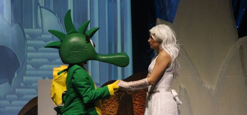 Der kleine grüne Drache Tabaluga und Lilli halten sich an den Händen.