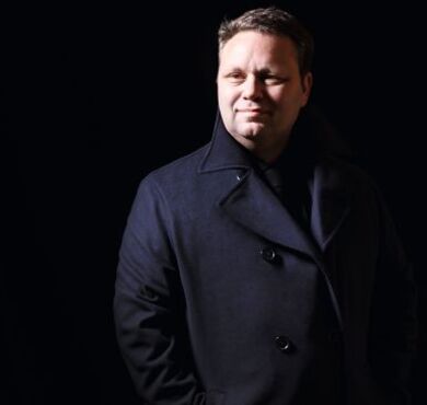 Der weltberühmte Tenor Paul Potts vor schwarzem Hintergrund.