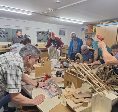 Krippenbaukurs in Altötting, Foto Krippenfreunde Altötting e.V. Teilnehmer des Krippenbaukurses bauen gerade an ihrer Krippe.