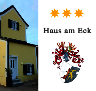 Haus in gelber Farbe mit Logo und Wappen rechts. 