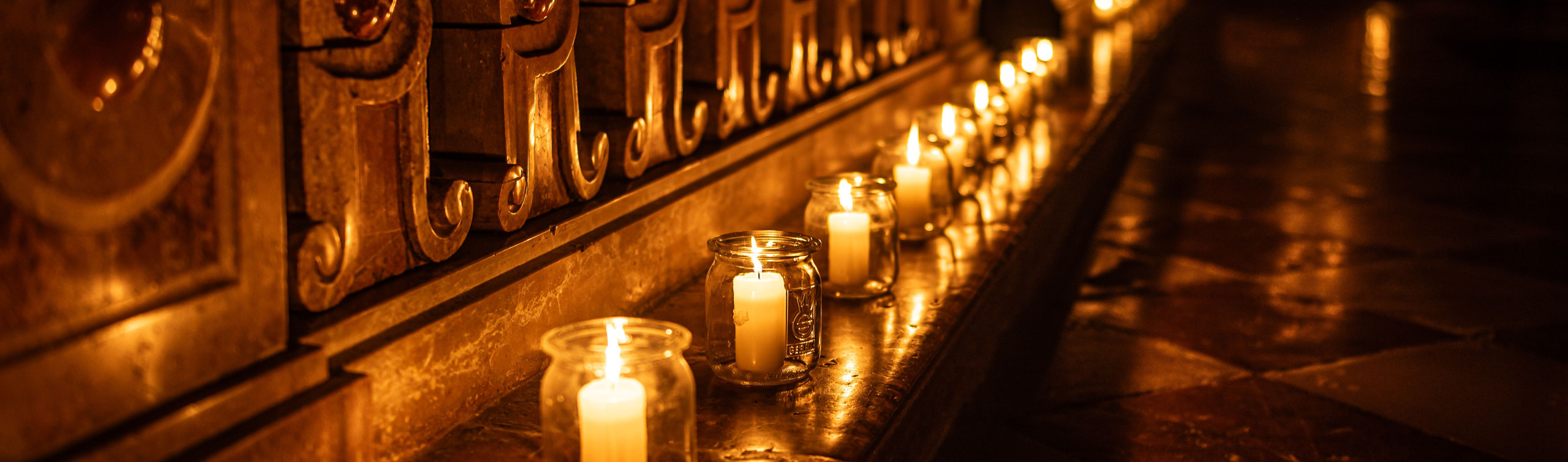 Kerzen stehen an den Bankreihen der Kirchen und dienen als Beleuchtung.