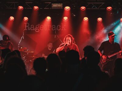 Band auf einer Bühne mit rotem Bühnenlicht. 