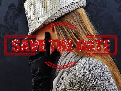 Eine junge Frau mit silbernem Hut und schwarzen Handschuhen ist nur von der Seite zu sehen.