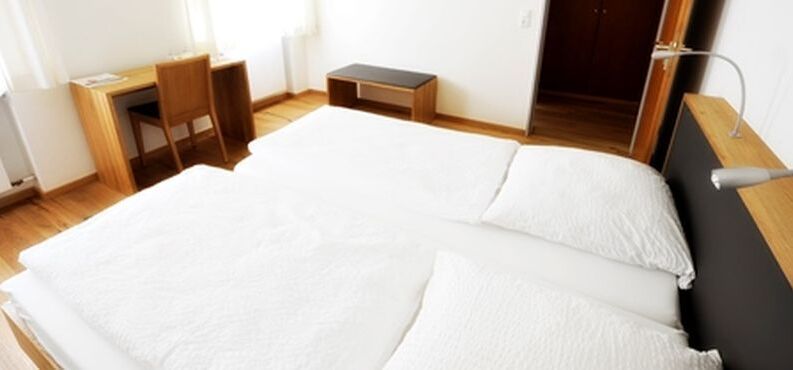 Schlafzimmer mit weißer Bettwäsche.