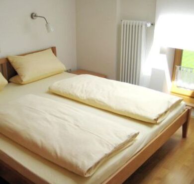Doppelbett mit gelber Bettwäsche