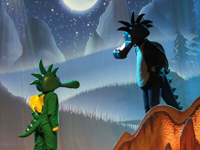 Der kleine grüne Drache Tabaluga spricht mit seinem Vater. 