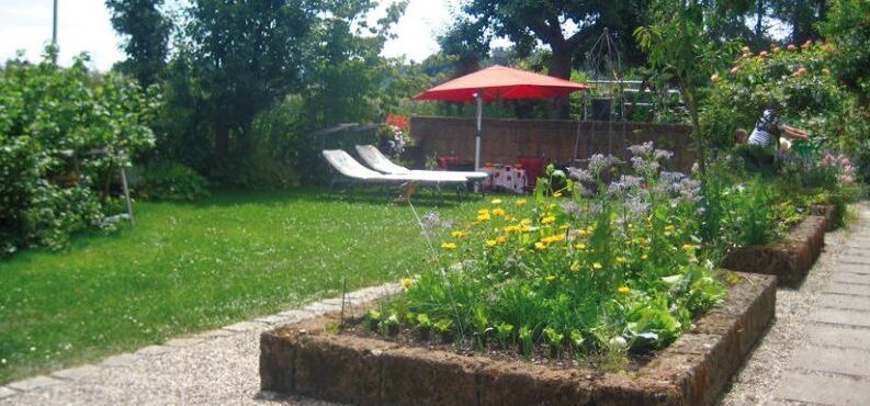 Garten mit zwei Liegen und Sonnenschirm