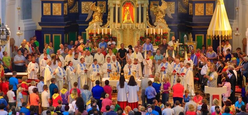 Eine große Pilgergruppe feiert in der Basilika einen Gottesdienst.