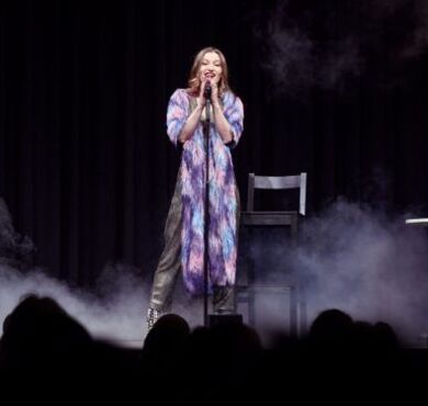 Die junge Kabarettistin Malarina steht auf der Bühne am Mikro im Nebel.