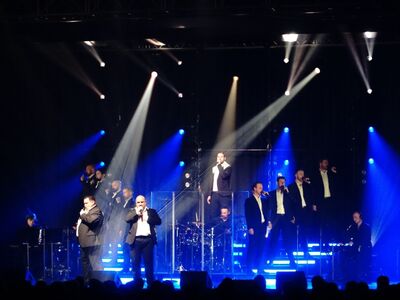 The 12 Tenors, Forum, Altötting, Foto Veranstalter 12 Sänger in schwarzen Anzügen auf der Bühne.