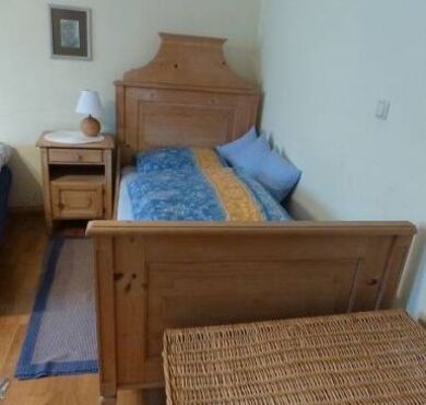 altes Holzbett als Einzelbett mit blauer Bettwäsche