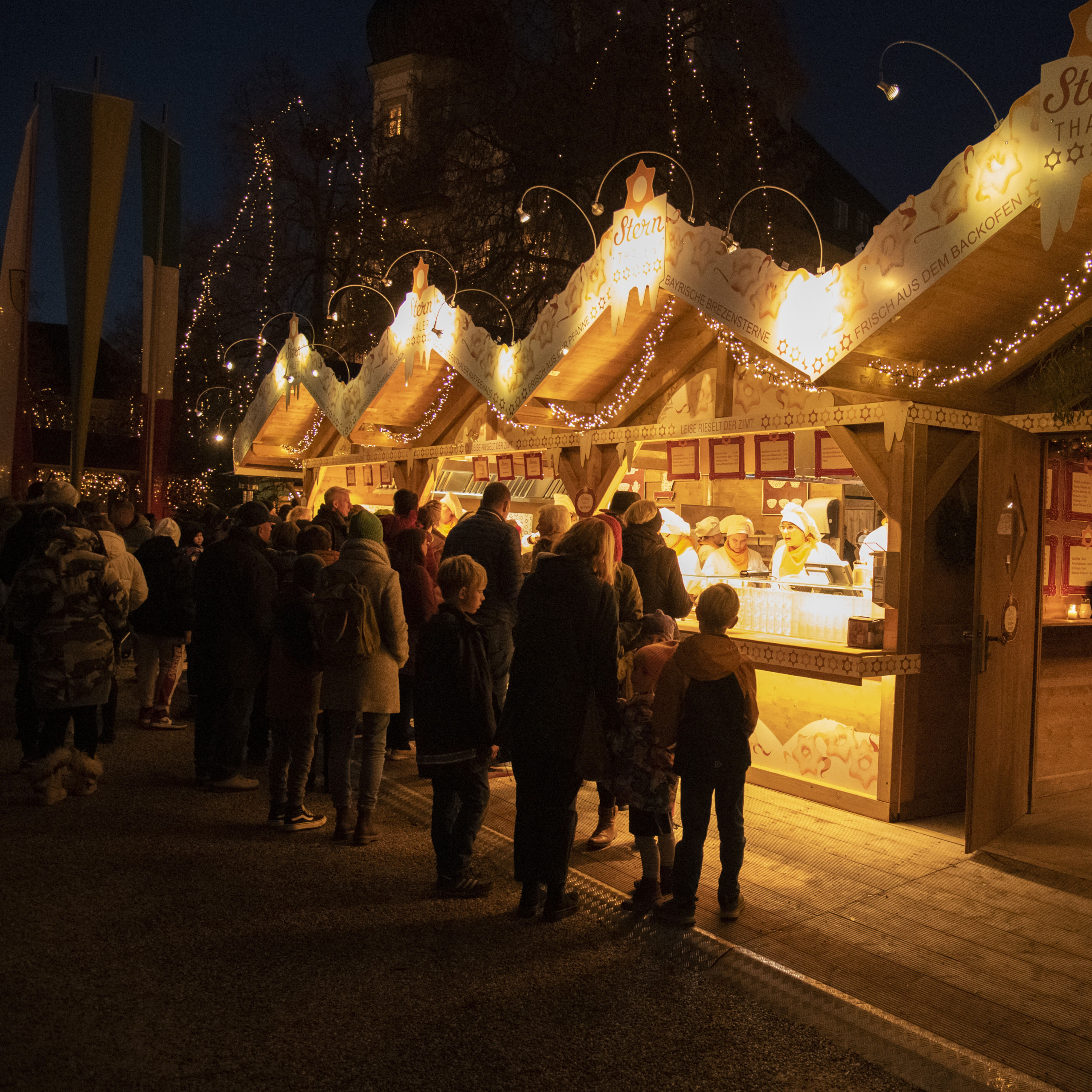 Markttreiben am stimmungsvollen Christkindlmarkt Altötting in der Dämmerung. 