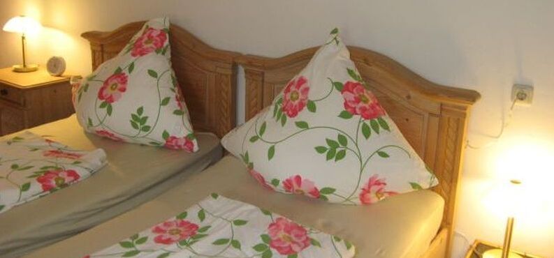 Bett mit Blumenbettwäsche