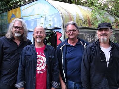 Günther Grünwald, Rad Gumbo, Forum Altötting, Bild Veranstalter Vier ältere Männer stehen vor einem bunt bemalten Bauwagen.