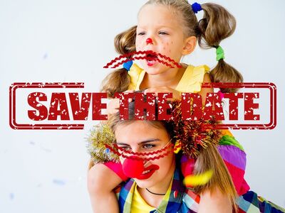 Eine Frau mit Kind im Faschingskostüm mit roter Pappnase.