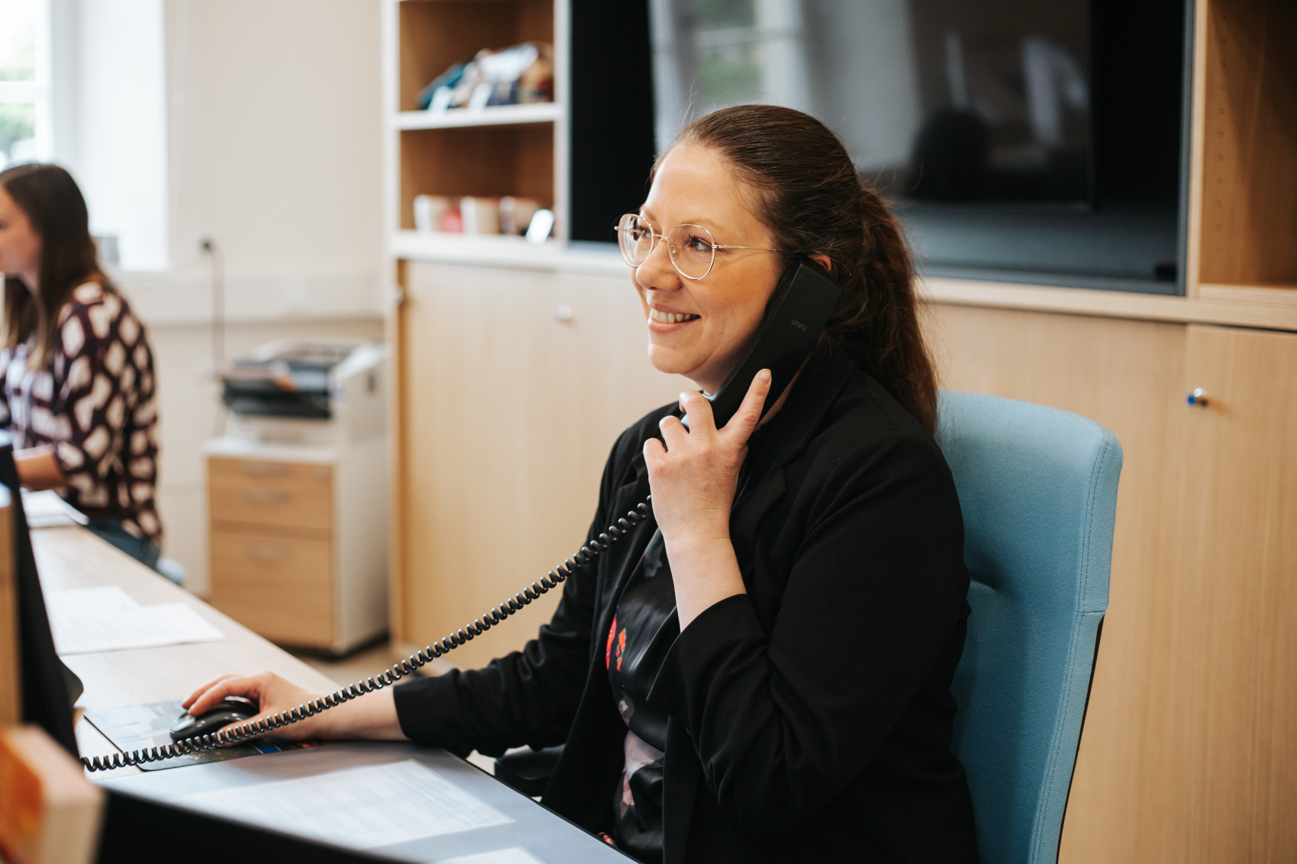 Eine Frau telefoniert und lächelt. 