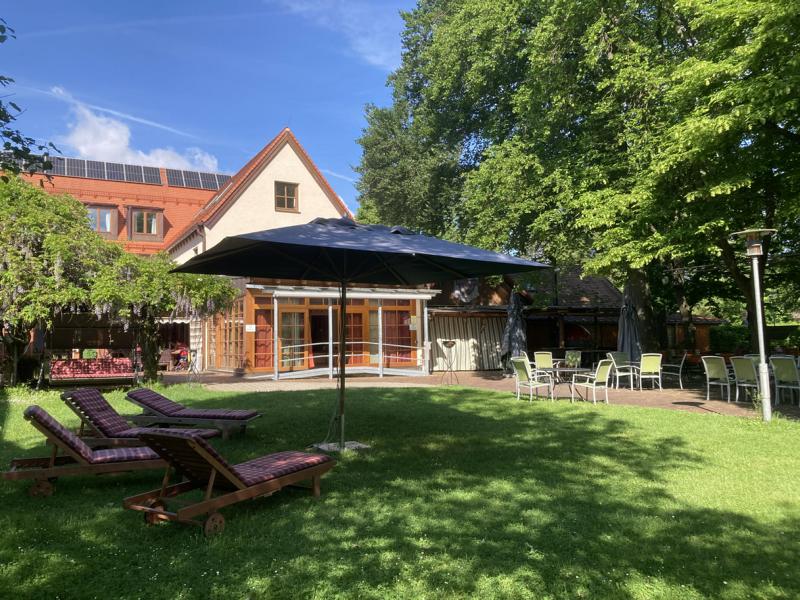 Gartenansicht des Caritashaus St. Elisabeth mit Liegestühlen im Vordergrund.