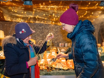 Weihnacht Rauhnacht Neujahrszauber Führung in Altötting, Foto Dirschl Zwei Frauen zünden Weirauch in einem Weihrauchfass an.