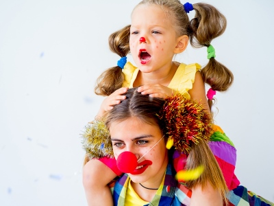 Kinderfasching, Forum Altötting, Foto IStock Eine Frau mit Kind im Faschingskostüm mit roter Pappnase.