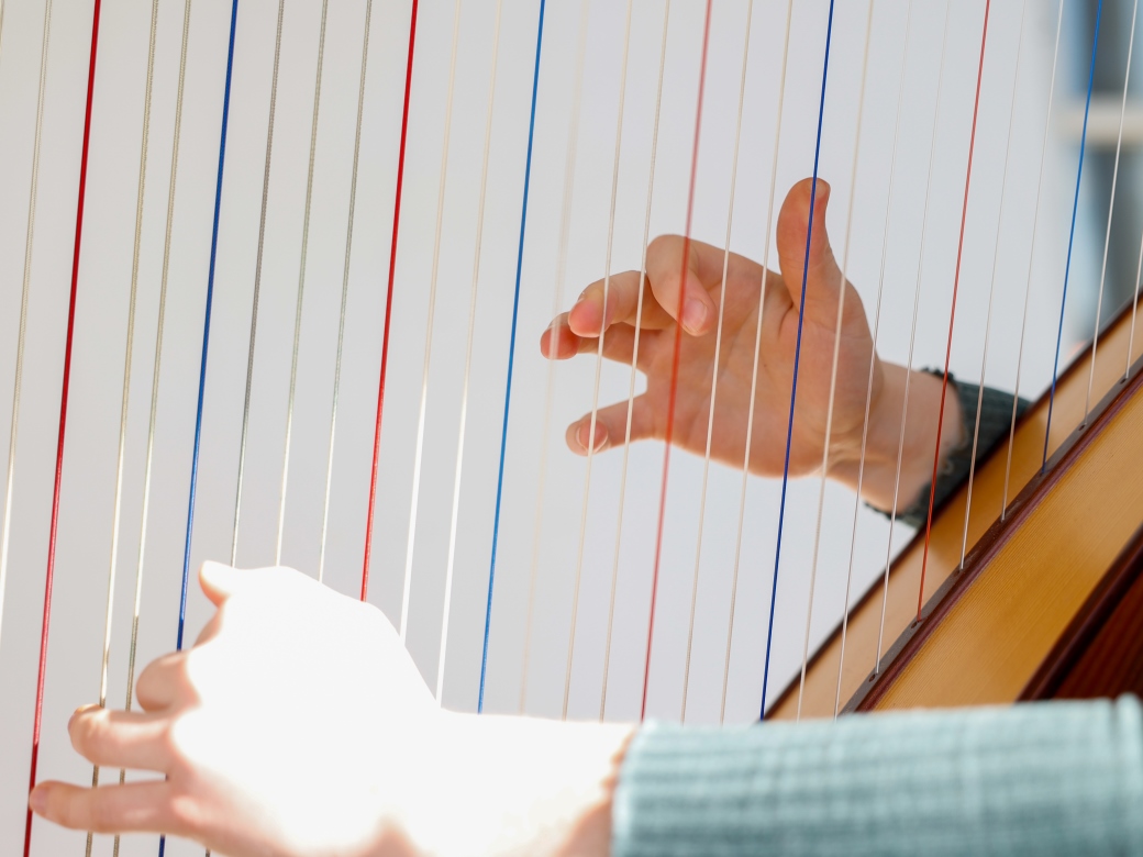 Eine Frau spielt Harfe. 