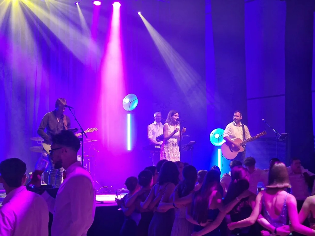 Eine Band auf einer Bühne mit farbigem Licht.