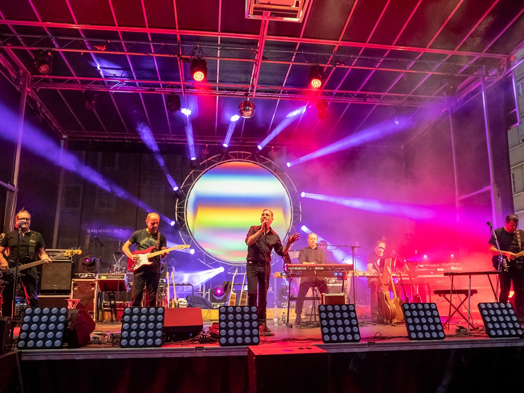 Yet another Floyd, Pink Floyd Tribute, Forum Altoetting, Bild Oliver Lakota Musiker auf einer rot erleuchteten Bühne.