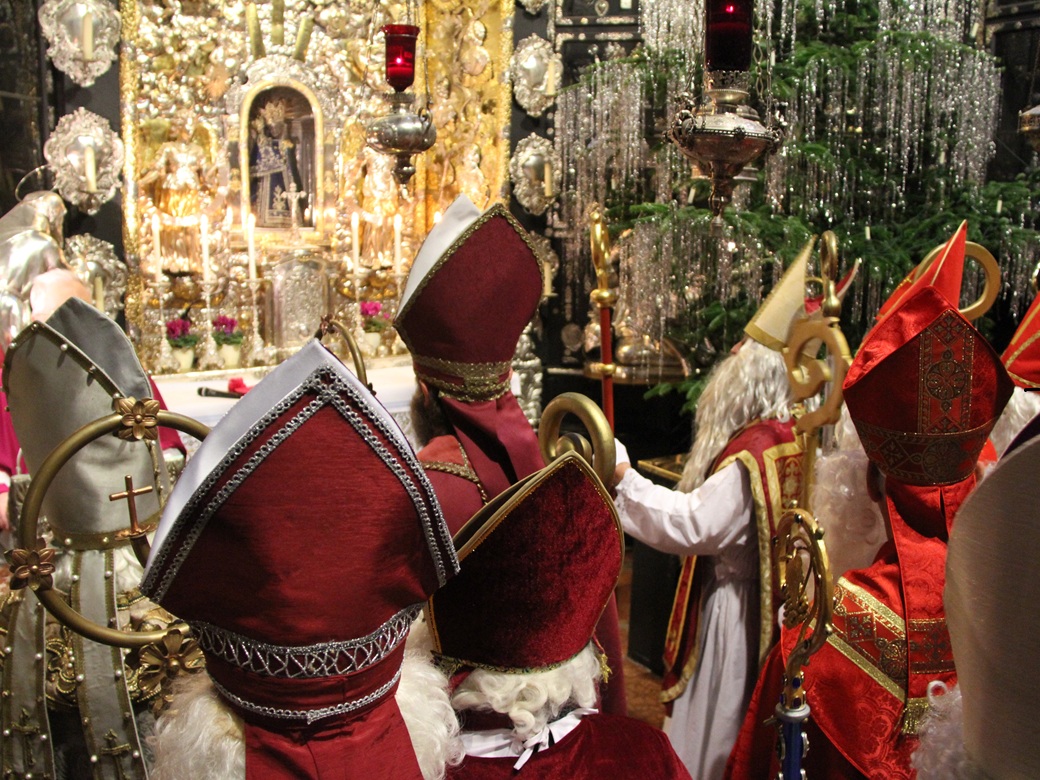Nikolaus Wallfahrt, Altötting, Bild Christian Wieser Nikoläuse in rotem Gewand in einer Kirche.