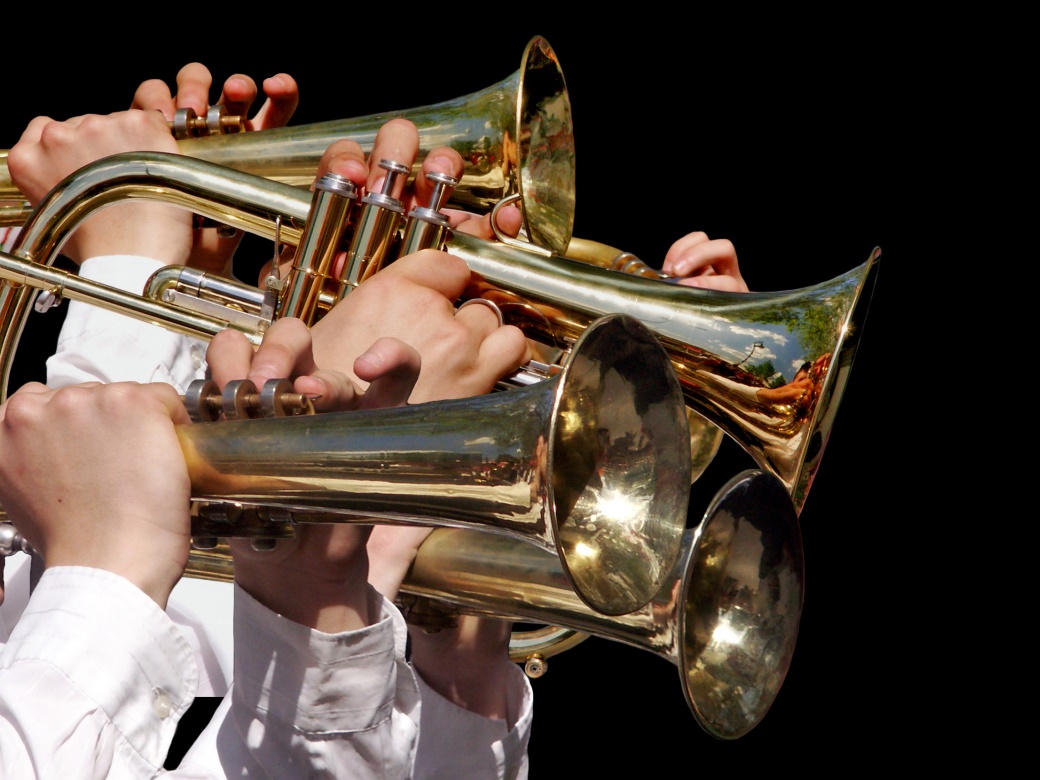 Es sind vier Trompeten mit acht Händen vor schwarzem Hintergrund zu sehen.