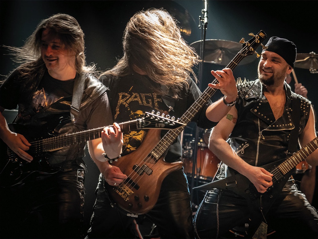 Manomore, Manoware, Abriss, Forum, Altötting, Bild Anima Nigra Drei Männer mit Gitarren stehen auf der Bühne und schwingen die Haare zum Head Banging.