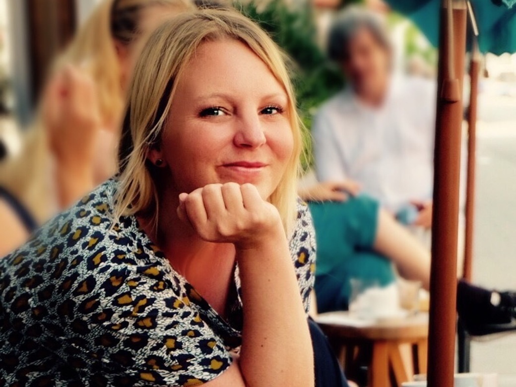 Mitzi Irsaj, Fest der Sinne, Altoetting, Bild Irsaj Eine Frau sitzt in einem Straßencafe.