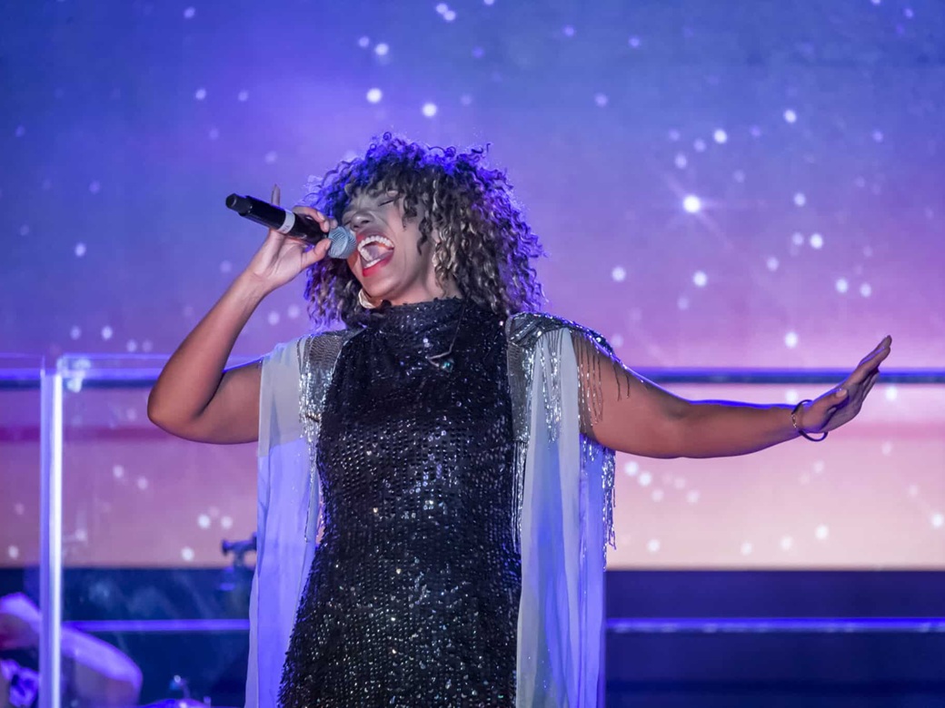 Tina, The Rock Legend, Forum, Altoetting, Bild Ralf Ruehmeier Eine Frau im Glitzerkleid am Mikrofon.