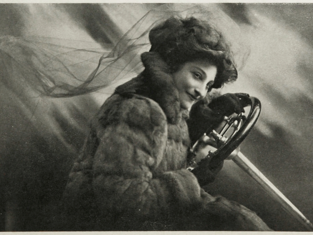 Kultur im Rathaus, Altoetting, Portrait Fotografie Dorothy Levitt, Frauen, Autos, Courage Dorothy Levitt mit Lenkrad vor einem abstrakten Fotohintergrund