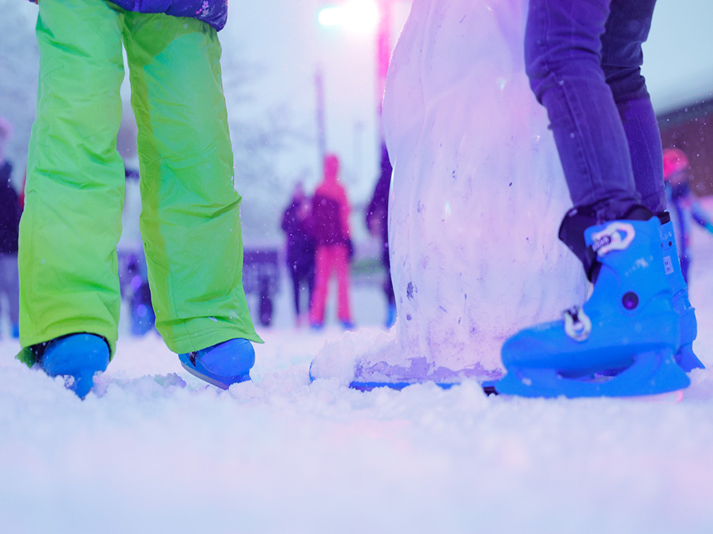 Schlittschuhe von 2 Eisläufern auf der Eisbahn.
