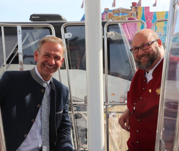 Zwei Herren schauen aus einer Riesenrad-Kabine