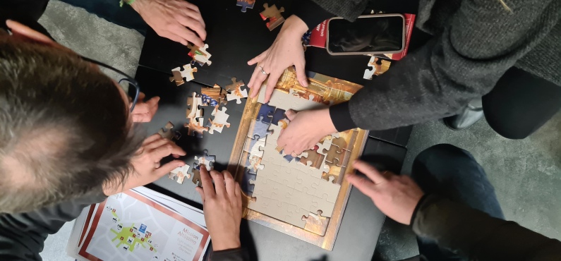 Mehrere Menschen versuchen ein Puzzle zu lösen.