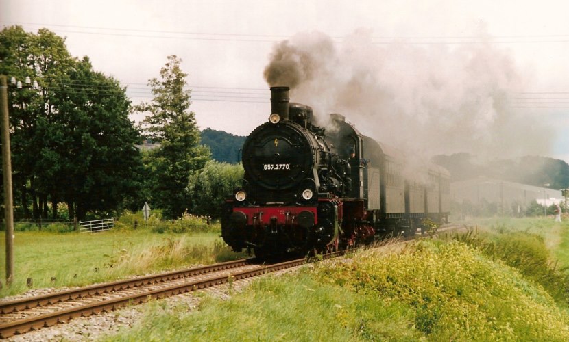 Eine Dampflok von vorne, mit viel Rauch, als sie zum Bahnhofsfest nach Altötting 2005 fährt.