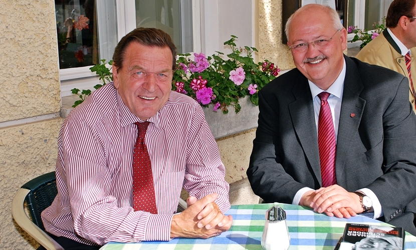Der Altöttinger Bürgermeister mit Bundeskanzler a. D. Gerhard Schröder bei seinem Besuch 2009 an einem Tisch von einem Gasthaus im Außensitz.