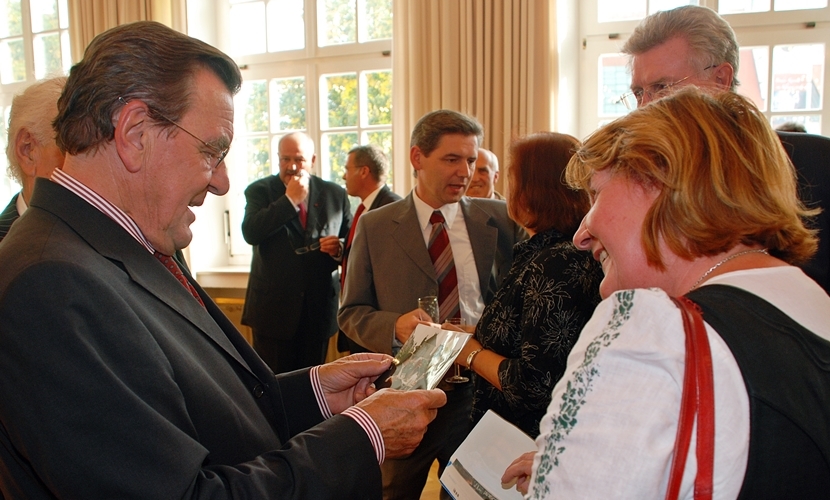 Der Bundeskanzler a. D. Gerhard Schröder sieht sich Bilder an bei seinem Besuch 2009 in Altötting.