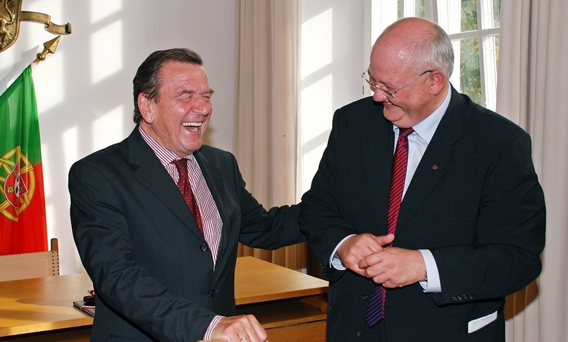Der Bundeskanzler a. D. Gerhard Schröder bekommt bei seinem Besuch in Altötting 2009 vom Bürgermeister einen halbe Krug geschenkt und lacht herzhaft.