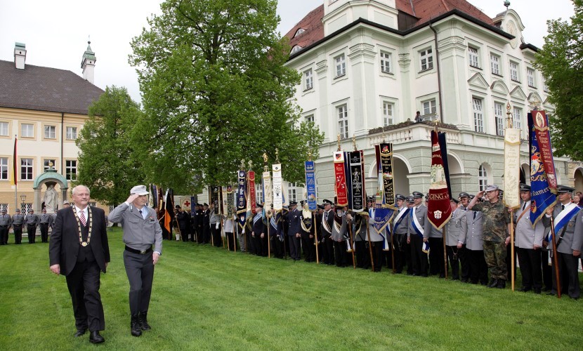 Der Altöttinger Bürgermeister geht mit einem Komandanten der Bundeswehr an einer Truppe mit Fahnen vorbei, bei dem Gelöbnis 2013 in Altötting.