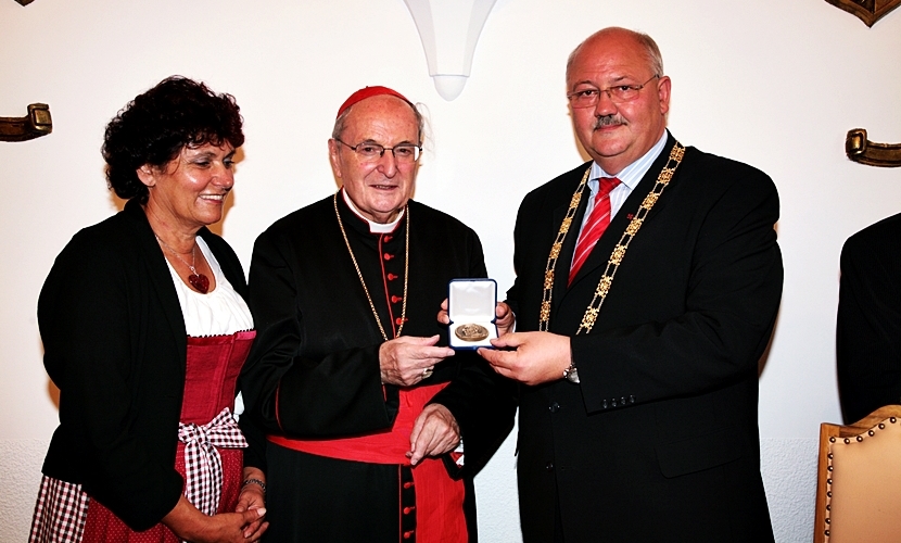 Der Altöttinger Bürgermeister übergibt eine goldene Münze bei der Verleihung der Goldenen Rose an Altötting.